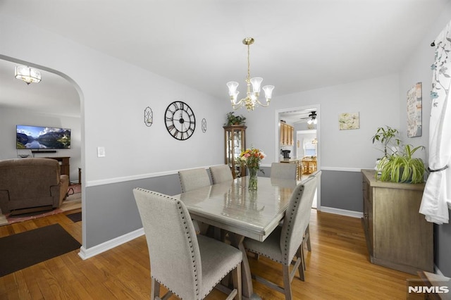 101 Pasadena Pl, Hawthorne, NJ 07506 - dining room with a chandelier, arched walkways, light wood-style flooring, and ceiling fan