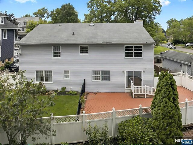 114 Summit Cross, Rutherford, NJ 07070 - rear view of house featuring a fenced backyard, a chimney, and a patio area