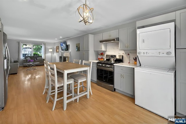 114 Summit Cross, Rutherford, NJ 07070 - kitchen with appliances with stainless steel finishes, stacked washer / dryer, gray cabinets, under cabinet range hood, and crown molding