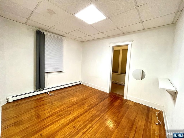 208 Wayne Ave, Cliffside Park, NJ 07010 - spare room featuring a baseboard heating unit, a drop ceiling, wood-type flooring, and baseboards