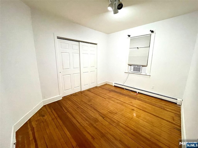 208 Wayne Ave, Cliffside Park, NJ 07010 - unfurnished bedroom with a baseboard heating unit, wood finished floors, a closet, cooling unit, and baseboards