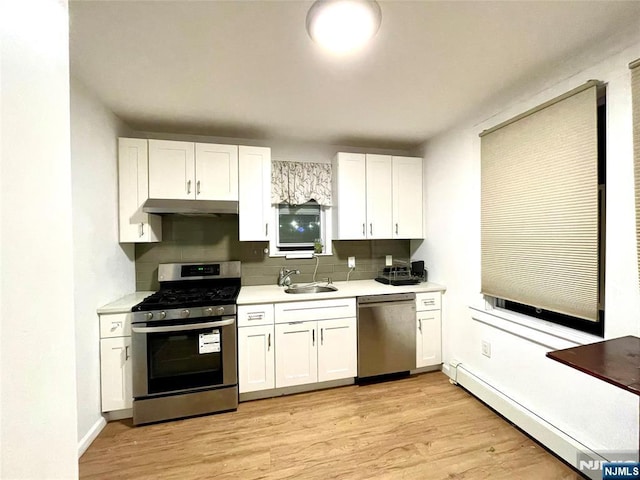 208 Wayne Ave, Cliffside Park, NJ 07010 - kitchen with appliances with stainless steel finishes, under cabinet range hood, light countertops, white cabinets, and a baseboard radiator