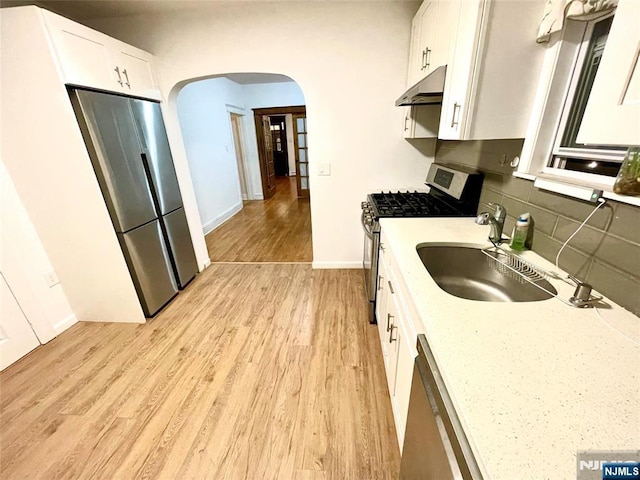 208 Wayne Ave, Cliffside Park, NJ 07010 - kitchen featuring stainless steel appliances, arched walkways, light wood-type flooring, under cabinet range hood, and white cabinets