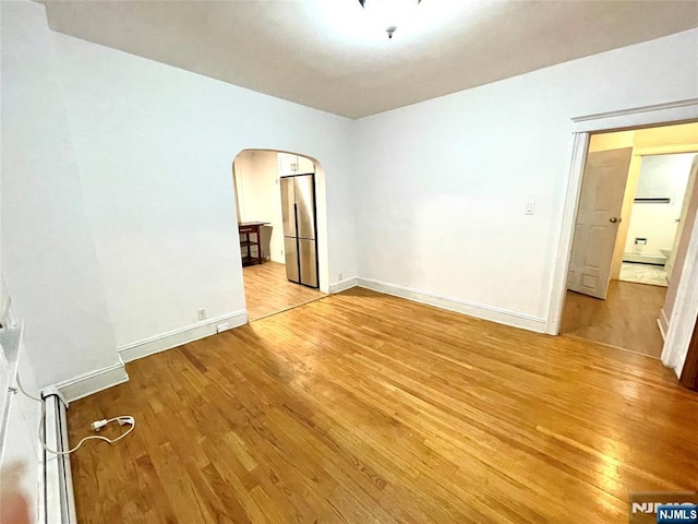 208 Wayne Ave, Cliffside Park, NJ 07010 - spare room featuring light wood-style flooring, arched walkways, and baseboards