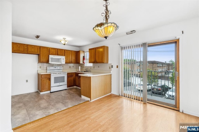 239 40th St Unit C0007, Irvington, NJ 07111 - kitchen with white appliances, brown cabinetry, light countertops, decorative backsplash, and decorative light fixtures