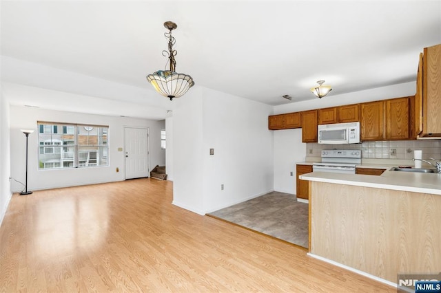 239 40th St Unit C0007, Irvington, NJ 07111 - kitchen with white appliances, a sink, light countertops, and light wood-type flooring