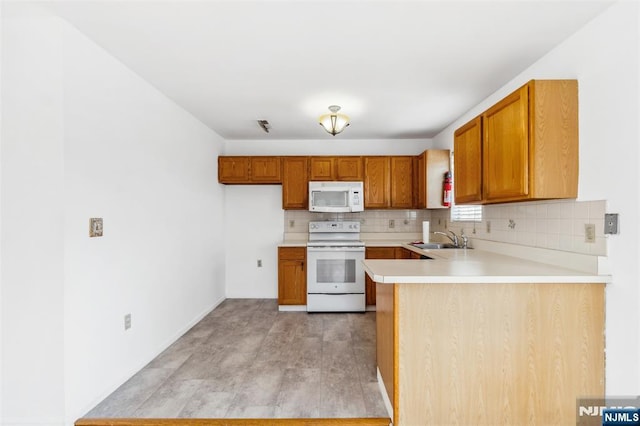239 40th St Unit C0007, Irvington, NJ 07111 - kitchen with white appliances, a sink, decorative backsplash, and brown cabinetry