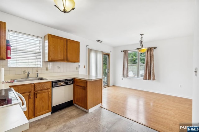 239 40th St Unit C0007, Irvington, NJ 07111 - kitchen featuring dishwasher, a peninsula, tasteful backsplash, light countertops, and a sink
