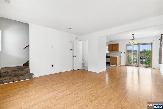 239 40th St Unit C0007, Irvington, NJ 07111 - unfurnished living room featuring light wood-type flooring, stairs, a chandelier, and baseboards