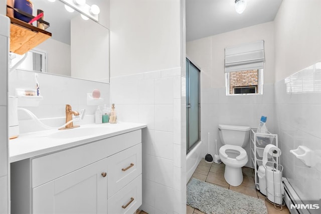 755 Jefferson Ave, Cliffside Park, NJ 07010 - bathroom featuring a baseboard radiator, tile walls, toilet, vanity, and tile patterned floors