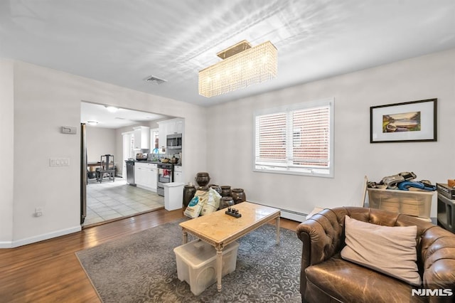 755 Jefferson Ave, Cliffside Park, NJ 07010 - living area featuring wood finished floors, baseboard heating, and baseboards