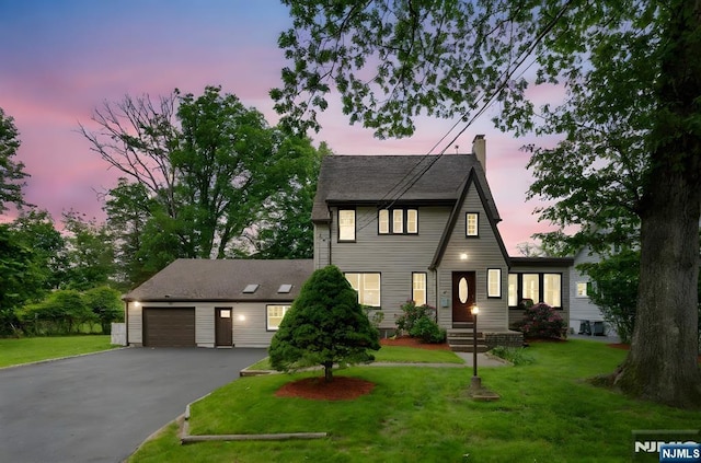 41 Oakland Ave, Westwood, NJ 07675 - view of front facade with asphalt driveway, a chimney, a garage, and a front lawn