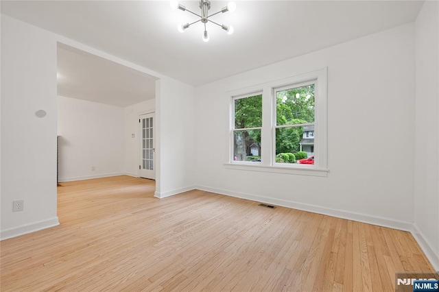 41 Oakland Ave, Westwood, NJ 07675 - empty room with wood finished floors, a chandelier, and baseboards