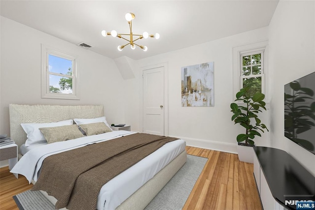 41 Oakland Ave, Westwood, NJ 07675 - bedroom with a chandelier, multiple windows, light wood-type flooring, and baseboards
