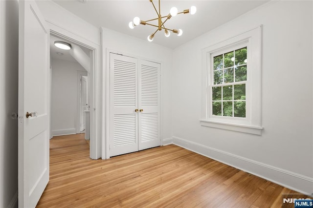 41 Oakland Ave, Westwood, NJ 07675 - unfurnished bedroom featuring a chandelier, light wood-style flooring, a closet, and baseboards