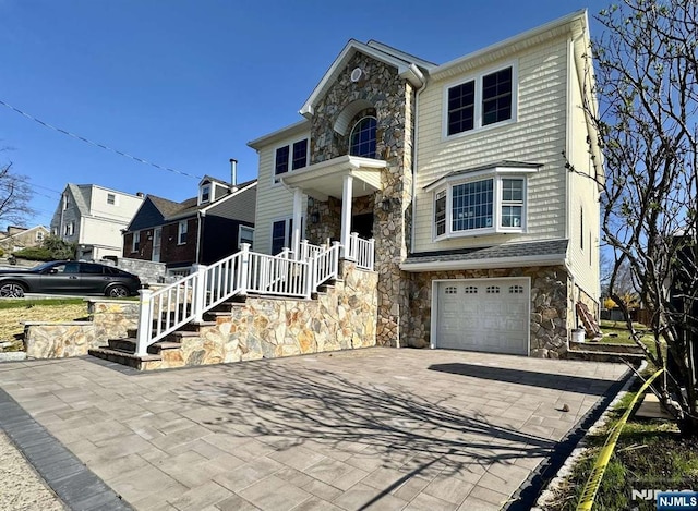 178 Leonard Pl, North Arlington, NJ 07031 - traditional home with stone siding, driveway, an attached garage, and stairs