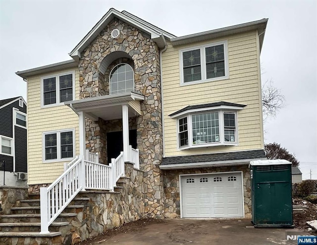 178 Leonard Pl, North Arlington, NJ 07031 - view of front facade featuring stone siding, an attached garage, driveway, and stairs