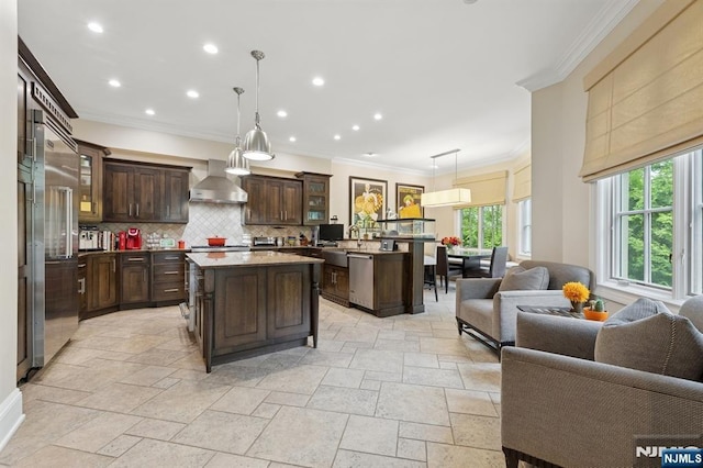 511 Bellaire Dr, Demarest, NJ 07627 - kitchen featuring open floor plan, wall chimney exhaust hood, dark brown cabinetry, crown molding, and a kitchen island