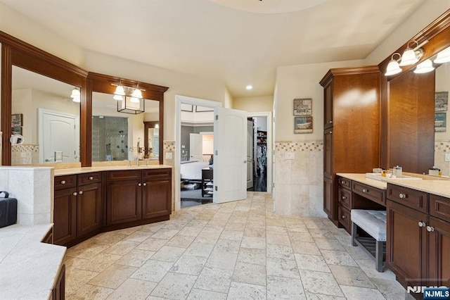 511 Bellaire Dr, Demarest, NJ 07627 - full bathroom with tile walls, vanity, a shower, a spacious closet, and stone tile floors