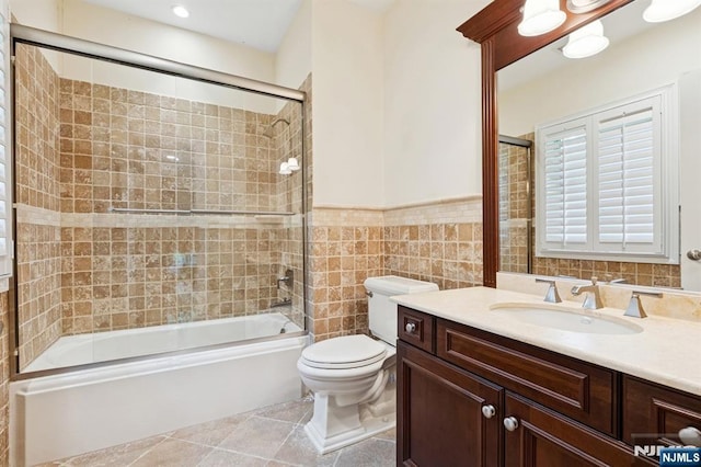 511 Bellaire Dr, Demarest, NJ 07627 - full bath with vanity, toilet, bath / shower combo with glass door, tile walls, and wainscoting
