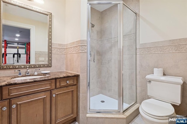 511 Bellaire Dr, Demarest, NJ 07627 - bathroom with tile walls, toilet, vanity, a shower stall, and wainscoting