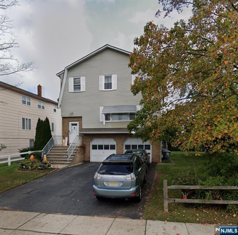 71 Miles St, Elmwood Park, NJ 07407 - view of front of home with asphalt driveway, a garage, and brick siding