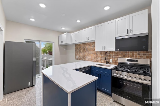 99 W 50th St, Bayonne, NJ 07002 - kitchen featuring stainless steel appliances, a sink, a peninsula, white cabinetry, and recessed lighting