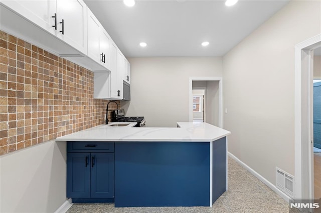 99 W 50th St, Bayonne, NJ 07002 - kitchen featuring a peninsula, recessed lighting, white cabinets, decorative backsplash, and baseboards