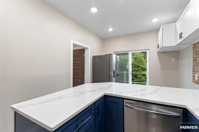 99 W 50th St, Bayonne, NJ 07002 - kitchen featuring stainless steel appliances, white cabinetry, blue cabinetry, light stone counters, and recessed lighting