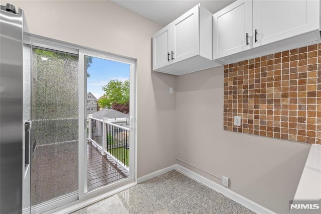99 W 50th St, Bayonne, NJ 07002 - kitchen with white cabinetry, baseboards, and tasteful backsplash