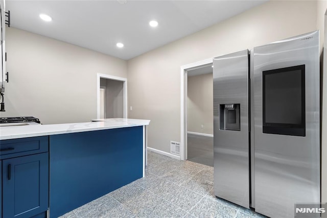 99 W 50th St, Bayonne, NJ 07002 - kitchen with stainless steel fridge with ice dispenser, recessed lighting, blue cabinets, light stone counters, and baseboards