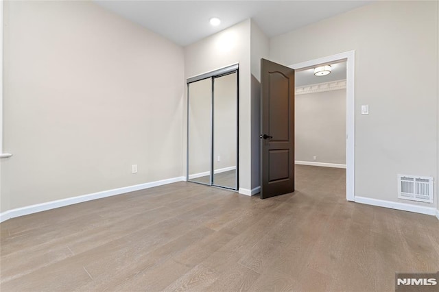 99 W 50th St, Bayonne, NJ 07002 - unfurnished bedroom featuring wood finished floors, baseboards, and a closet
