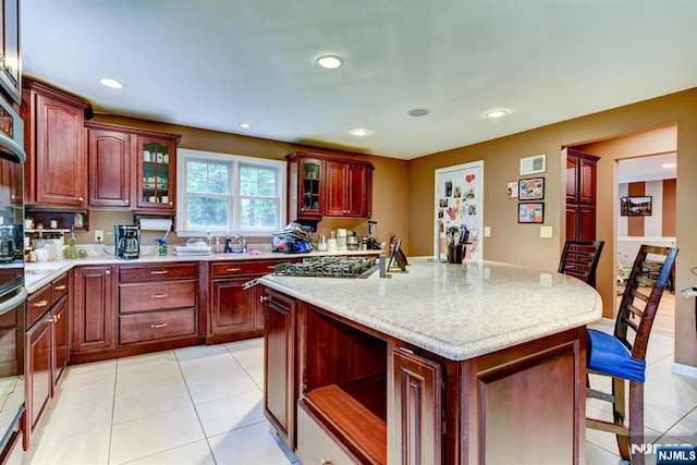 25 Fern Ter, Wayne, NJ 07470 - kitchen featuring a breakfast bar area, dark brown cabinets, light tile patterned floors, recessed lighting, and glass insert cabinets