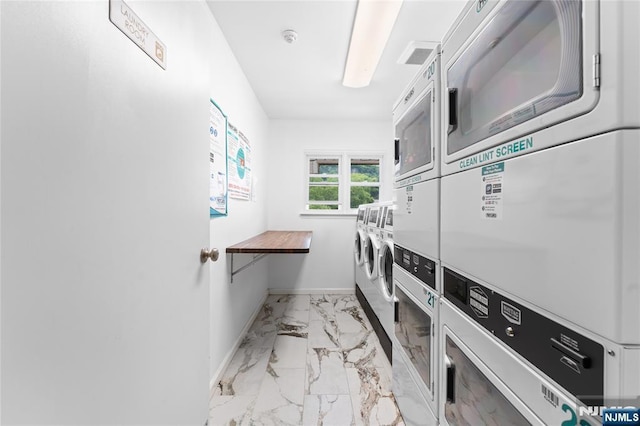 1111 River Rd Unit F25, Edgewater, NJ 07020 - shared laundry featuring stacked washer / dryer, marble finish flooring, baseboards, and washing machine and clothes dryer