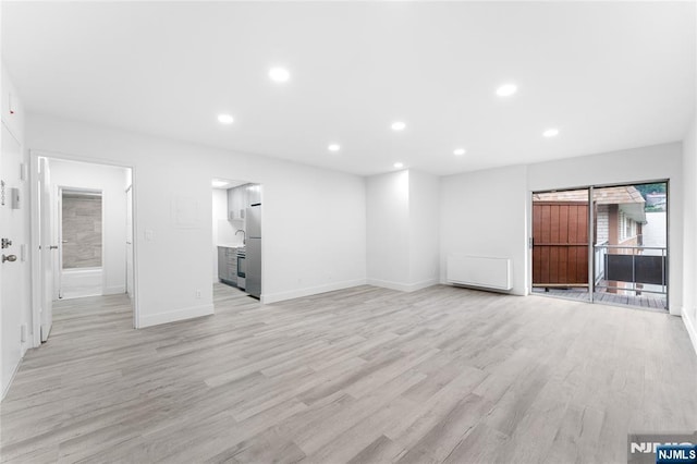 1111 River Rd Unit F25, Edgewater, NJ 07020 - unfurnished living room with light wood-style flooring, recessed lighting, and baseboards