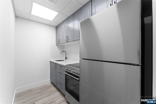 1111 River Rd Unit F25, Edgewater, NJ 07020 - kitchen with stainless steel appliances, gray cabinets, a sink, backsplash, and light wood-type flooring