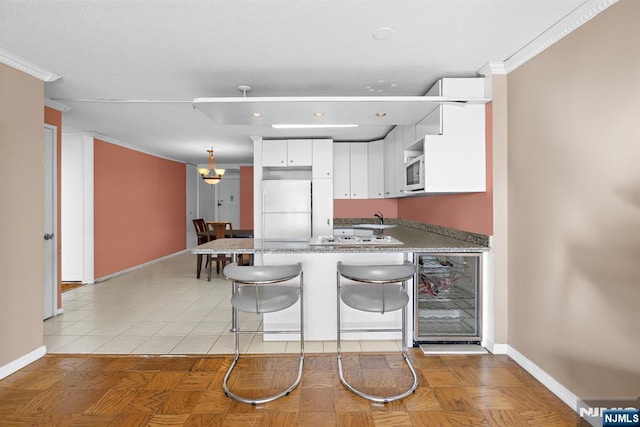 7004JFKB 70th Unit 40G, Guttenberg, NJ 07093 - kitchen featuring refrigerator, beverage cooler, a peninsula, baseboards, and a sink