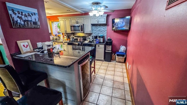 18 Trinity Pl, Kearny, NJ 07032 - kitchen with stainless steel microwave, stove, beverage cooler, a kitchen bar, and tasteful backsplash