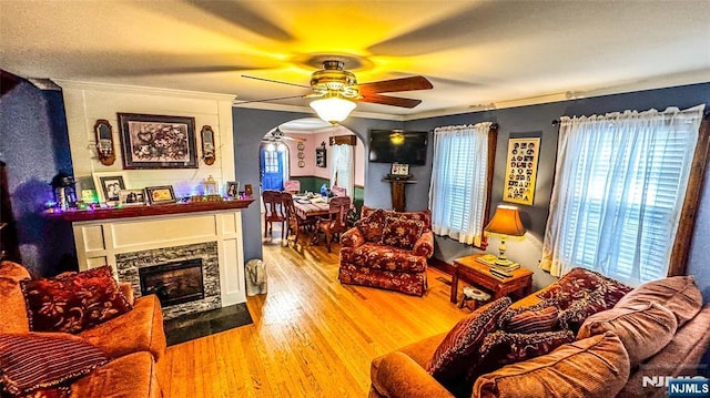 18 Trinity Pl, Kearny, NJ 07032 - living area featuring arched walkways, a ceiling fan, crown molding, wood finished floors, and a fireplace with flush hearth