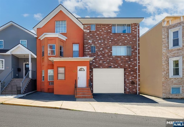 3912 Liberty Ave, North Bergen, NJ 07047 - view of property with driveway, brick siding, a garage, and entry steps