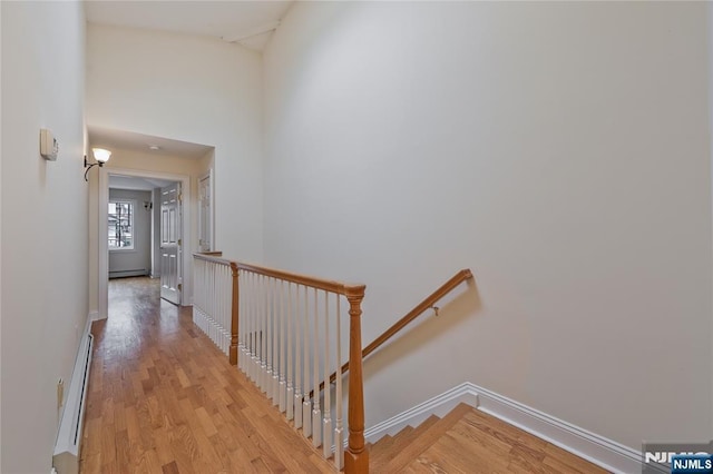 445B 7th St Unit B, Palisades Park, NJ 07650 - corridor featuring an upstairs landing, light wood-type flooring, a baseboard heating unit, and a high ceiling