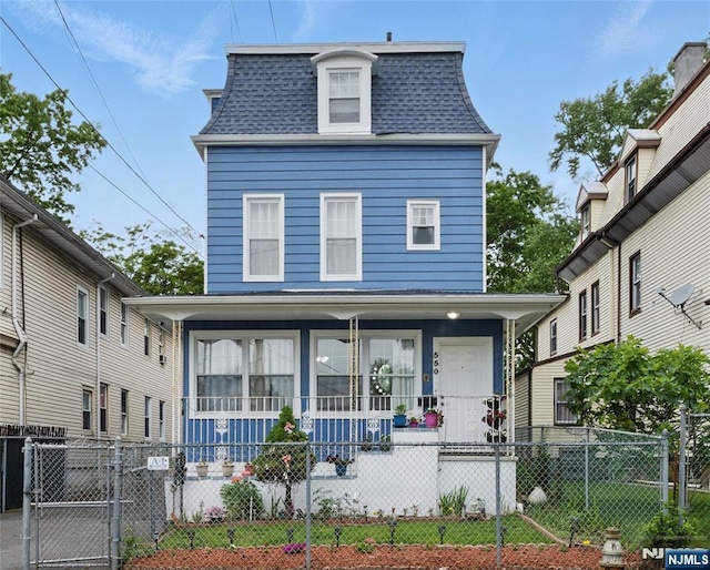 548 Jefferson Ave, Elizabeth, NJ 07201 - victorian home featuring covered porch, a shingled roof, mansard roof, a gate, and a fenced front yard