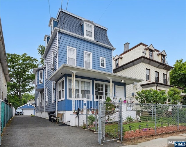 548 Jefferson Ave, Elizabeth, NJ 07201 - victorian home with mansard roof, covered porch, a fenced front yard, and roof with shingles