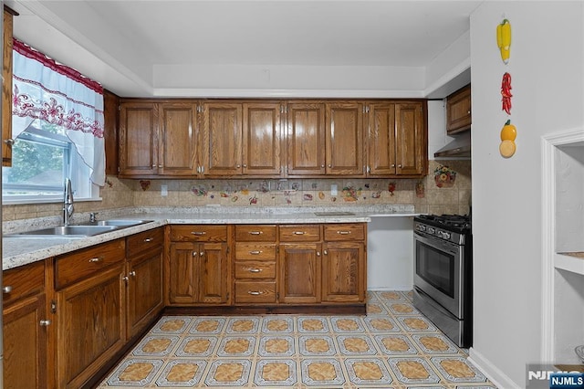 548 Jefferson Ave, Elizabeth, NJ 07201 - kitchen featuring stainless steel gas stove, a sink, light countertops, brown cabinets, and decorative backsplash