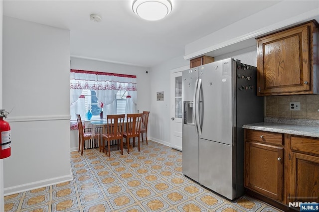 548 Jefferson Ave, Elizabeth, NJ 07201 - kitchen with stainless steel fridge, baseboards, brown cabinets, and light countertops