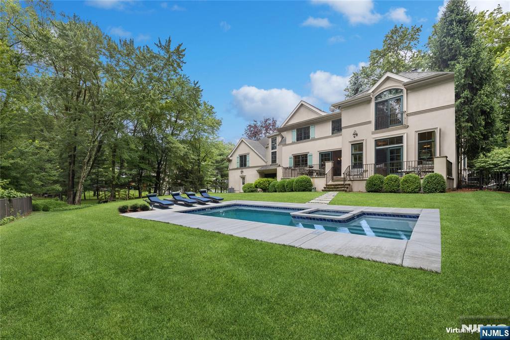 44 Central Ave, Demarest, NJ 07627 - back of property with stucco siding, a yard, and a pool with connected hot tub