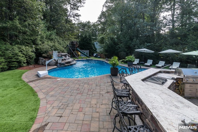 87 Skytop Dr, Mahwah, NJ 07430 - view of pool with an outdoor kitchen, a patio area, and view of scattered trees