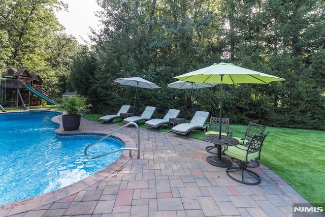 87 Skytop Dr, Mahwah, NJ 07430 - swimming pool featuring a patio, a playground, a yard, and view of wooded area