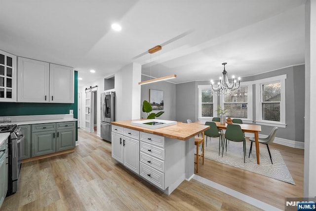 518 Bloomfield Ave, Nutley, NJ 07110 - kitchen featuring wooden counters, stainless steel appliances, a barn door, light wood-style floors, and a chandelier