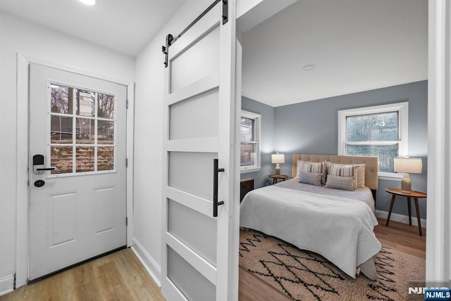 518 Bloomfield Ave, Nutley, NJ 07110 - bedroom featuring a barn door, wood finished floors, and baseboards